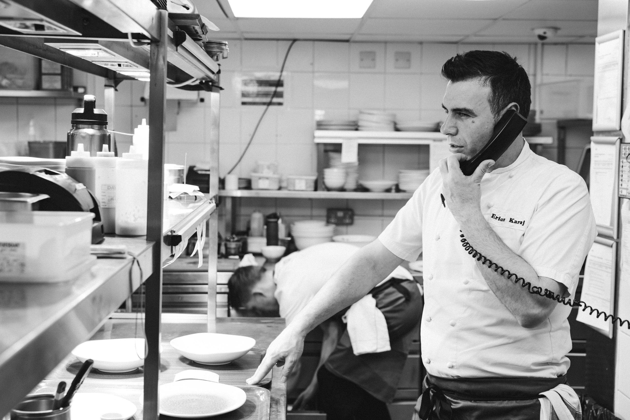 Chef Erion in the kitchen on the phone during service